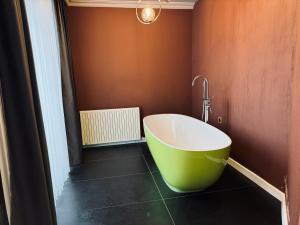 a bathroom with a large green tub in a room at WHITE MANSION in Arnavutköy
