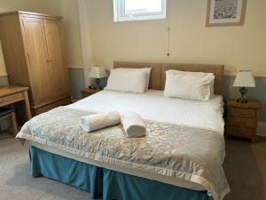 a bedroom with a bed with two towels on it at Harbour lights guesthouse room only in Weymouth