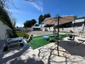 eine Terrasse mit Sonnenschirm und grünem Rasen in der Unterkunft Vesuvio 65 in Ercolano