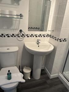 a white bathroom with a sink and a toilet at Harbour lights guesthouse room only in Weymouth