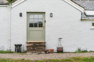 una casa bianca con una porta e un pilastro in pietra di Mellguards, 4-Bed Country Cottage, in Howtown a Watermillock