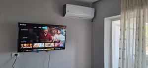 Elle comprend une télévision à écran plat suspendue au mur. dans l'établissement Ergi's Host Apartment, à Krujë