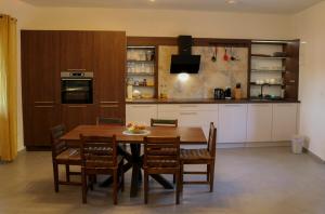 Villa Galleria في سوكوشان: مطبخ مع طاولة وكراسي خشبية في الغرفة