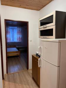 a kitchen with a refrigerator and a door to a room at Bieszczadzki Brzeg in Wołkowyja