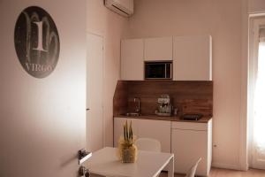 a small white kitchen with a table and a counter at LIBRA Appartaments in Salerno +5 photos