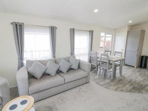 uma sala de estar com um sofá e uma mesa em Long Acres Lodge em Evesham