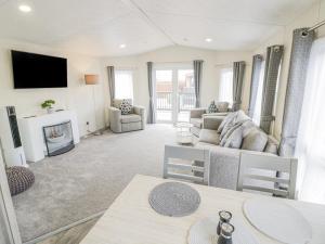 uma sala de estar com um sofá e uma lareira em Long Acres Lodge em Evesham