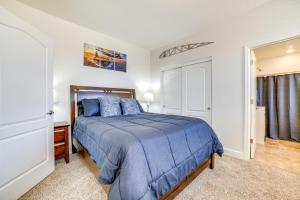 a bedroom with a bed with blue comforter at WWII Aviation-Themed Apt in Sparks Near Parks! in Sparks