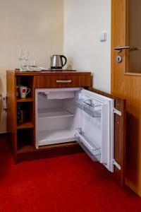 an empty refrigerator with its door open in a room at Relax Hotel Stork in Lednice