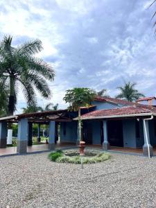 een blauw gebouw met palmbomen ervoor bij Casa Quinta Villa Cristal in Acacías