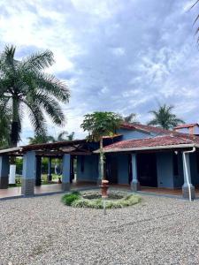 Un edificio azul con palmeras delante. en Casa Quinta Villa Cristal, en Acacías