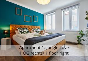 ein Schlafzimmer mit einem großen Bett mit blauer Wand in der Unterkunft nice2be Apartments in Augsburg