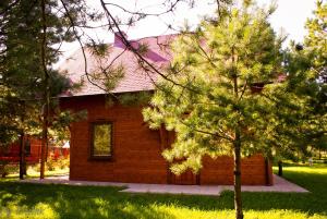 mały ceglany dom z drzewem przed nim w obiekcie Kociewiak Wycinki w mieście Wycinki