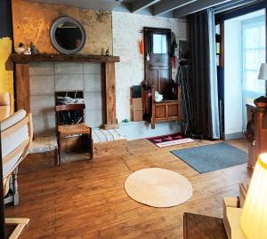 a living room with a fireplace and a wooden floor at Au bord de la rivière in Verteuil-sur-Charente