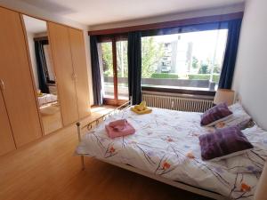 1 dormitorio con cama y ventana grande en Appartamento Roby, en Solduno