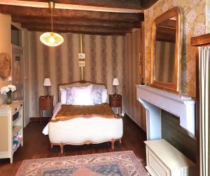 a bedroom with a bed and a fireplace at Au bord de la rivière in Verteuil-sur-Charente