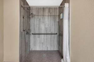 a bathroom with a shower with a shower curtain at Quality Inn Roseville-Detroit North in Roseville