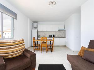 a living room with a couch and a table with chairs at EK Brisa Del Mar Caleta Arico in Arico