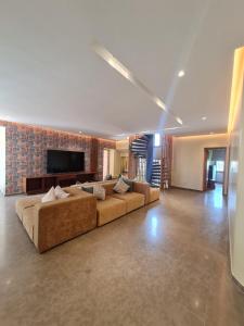 a large living room with a couch and a television at Villa familiale 5 chambres in Marrakech +30 photos