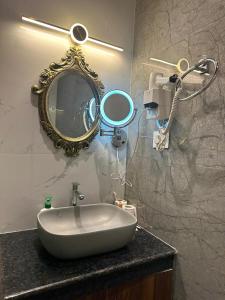 łazienka z umywalką i lustrem na ladzie w obiekcie YKC FARMS w mieście Bāghdogra