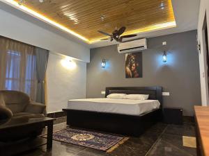 1 dormitorio con 1 cama y ventilador de techo en YKC FARMS en Bāghdogra