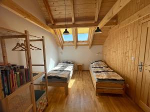 a room with two beds and a book shelf at PIEPRZ i Wanilia - Kopalino dom z widokiem na las 3 pokoje taras parking WiFi - Pieprz in Kopalino