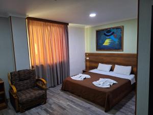 um quarto de hotel com uma cama e uma cadeira em Hotel Georgian Memory em Kutaisi