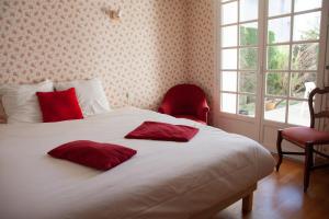 a bedroom with a bed with red pillows on it at Villa Topaze La Baule les Pins in La Baule