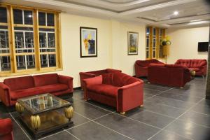 uma sala de estar com sofás vermelhos e uma mesa em Magnum Hotel em Battakundi