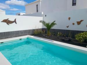 einen Pool im Hinterhof eines Hauses in der Unterkunft Splendid Casa Papagayo, heated pool, roofterrace with views and Wifi in Playa Blanca