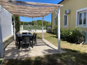 un patio con mesa y sillas bajo una pérgola en BEACH HOUSE - SEA FRONT- Narramondo Villas, en Giulianova