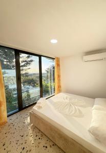 ein Schlafzimmer mit einem großen Bett und einem großen Fenster in der Unterkunft Bellavista Villa in Durrës