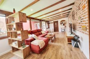 a living room with a red couch and a brick wall at Villa Lajares Red House Fuerteventura in Lajares