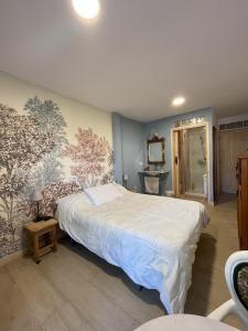 ein Schlafzimmer mit einem Bett und einem Wandbild in der Unterkunft Habitaciones Estrella del Norte in Santander