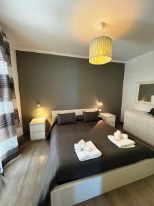 een slaapkamer met een groot bed en 2 handdoeken bij Elegante Appartamento Lungomare Kennedy in Otranto