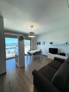 ein Wohnzimmer mit einem Sofa und einem Tisch mit Aussicht in der Unterkunft Elegante Appartamento Lungomare Kennedy in Otranto