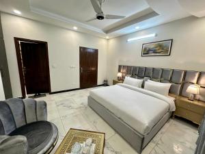 1 dormitorio con cama, sofá y sillas en Dream Executive Guest House en Islamabad