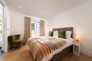 a bedroom with a bed with a green chair and a window at Tors Park in Lynmouth