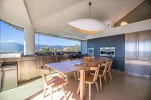 una cucina con un grande tavolo e sedie in legno di Villa a Luna Ruscana a Sainte-Lucie de Porto-Vecchio