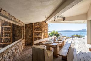 una sala da pranzo con tavolo e vista sull'oceano di Villa a Luna Ruscana a Sainte-Lucie de Porto-Vecchio