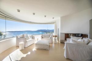 un soggiorno con mobili bianchi e una grande finestra di Villa a Luna Ruscana a Sainte-Lucie de Porto-Vecchio