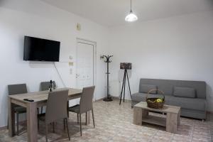 Blue Star Sea Apartment في أذيليانوس كامبوس: غرفة معيشة مع طاولة وأريكة