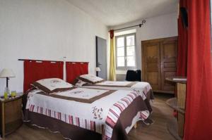 una camera con due letti con tende rosse e una finestra di L'Auberge de Mens a Mens