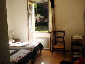 una camera con letto, finestra e sedia di L'Auberge de Mens a Mens