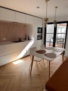 een keuken met witte kasten en een tafel bij Villa Frans Lichtrijk appartement 2slpk in Oostende