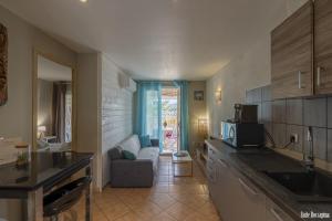 a kitchen and living room with a couch and a table at Résidence CasaBianca Porticcio - Roccapina in Porticcio