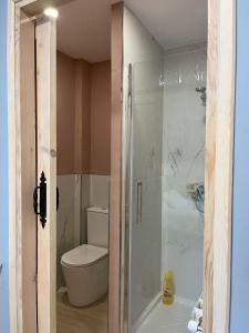 a bathroom with a toilet and a glass shower at Habitaciones Estrella del Norte in Santander