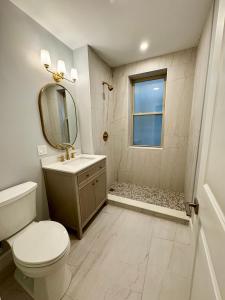 a bathroom with a toilet and a sink and a mirror at Cozy Nest in Chicago's Vibrant Lincoln Square in Chicago