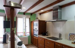 サンタンデールにあるHabitaciones Estrella del Norteの緑の壁と木製のキャビネット付きのキッチン