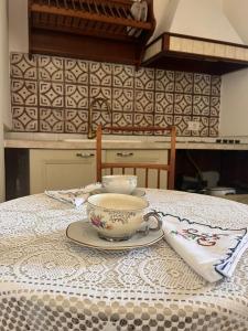 un tavolo con una tazza e un piattino sopra di Case GIALLA E ROSA a Pozzuoli